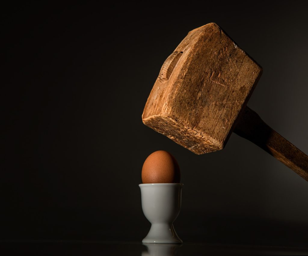 martello che sta per schiacciare un uovo